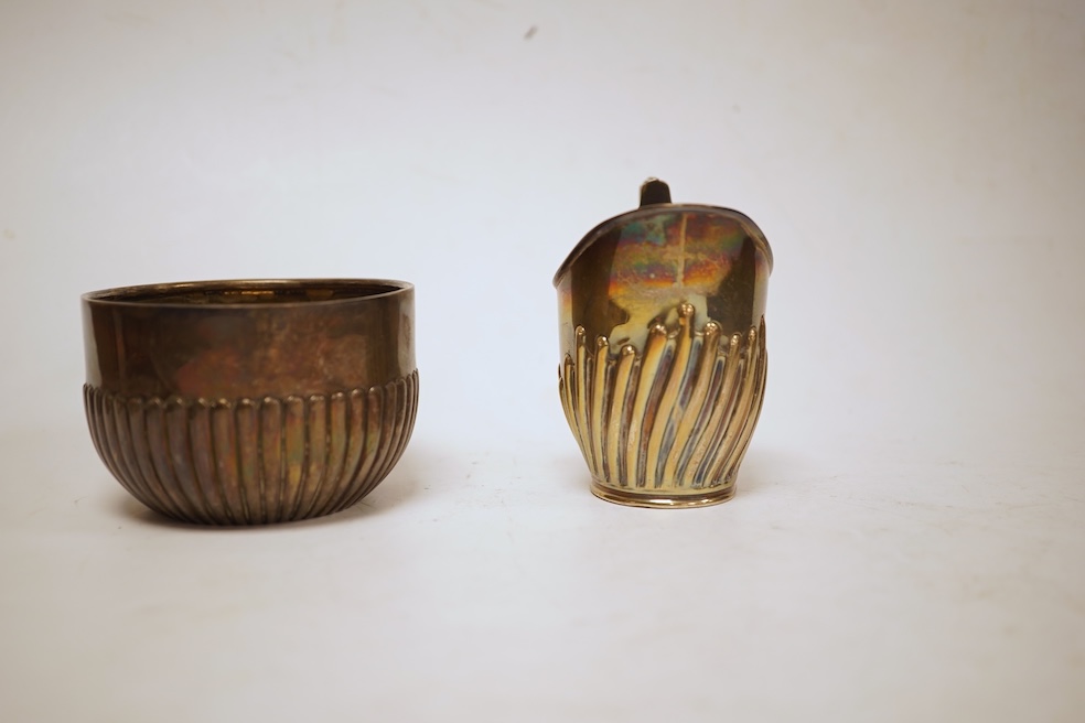 A late Victorian demi-fluted cream jug and sugar bowl, Charles Stuart Harris, London, 1888, together with cased silver christening egg cup, spoon and napkin ring and two other silver napkin rings.
